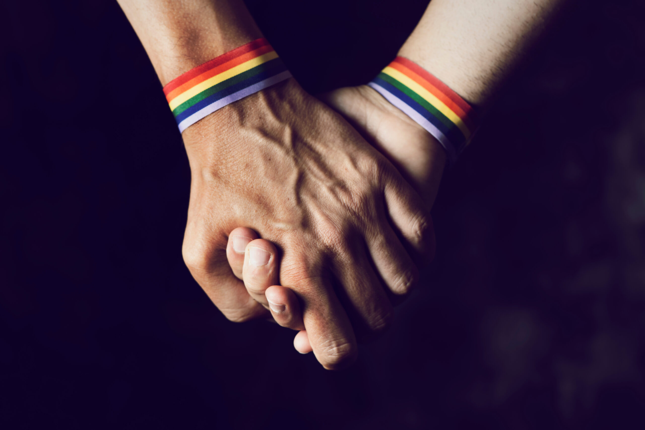 Closeup,Of,Two,Caucasian,Men,Holding,Hands,With,A,Rainbow-patterned